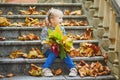 Adorable preschooler girl enjoying nice and sunny autumn day outdoors