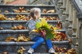 Adorable preschooler girl enjoying nice and sunny autumn day outdoors