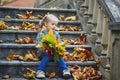 Adorable preschooler girl enjoying nice and sunny autumn day outdoors