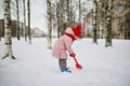 Adorable preschooler girl having fun in beautiful winter park on a snowy cold winter day Royalty Free Stock Photo