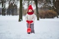 Adorable preschooler girl having fun in beautiful winter park on a snowy cold winter day Royalty Free Stock Photo