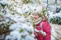 Adorable preschooler girl having fun in beautiful winter park on a snowy cold winter day Royalty Free Stock Photo