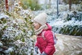 Adorable preschooler girl having fun in beautiful winter park on a snowy cold winter day Royalty Free Stock Photo