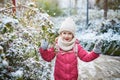 Adorable preschooler girl having fun in beautiful winter park on a snowy cold winter day Royalty Free Stock Photo