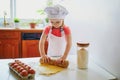 Adorable preschooler girl making cookies