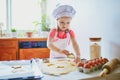 Adorable preschooler girl making cookies