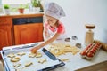 Adorable preschooler girl making cookies