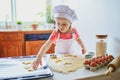 Adorable preschooler girl making cookies