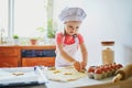 Adorable preschooler girl making cookies