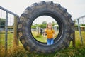Adorable preschooler girl staying inside old tractor wheel on Gally farm near Paris, France