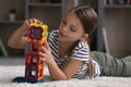 Adorable preteen age girl lying on carpet playing magnetic constructor Royalty Free Stock Photo