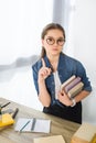 adorable preteen child showing one finger up and holding books