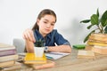 adorable preteen child touching potted plant at table with books