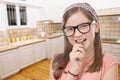 adorable preteen girl with glasses eats chocolate, kitchen background