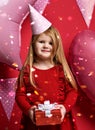 Adorable pretty girl with pink balloons and red present gift and birthday cap Royalty Free Stock Photo