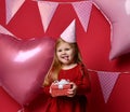 Adorable pretty girl with pink balloons and red present gift and birthday cap Royalty Free Stock Photo