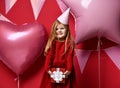 Adorable pretty girl with pink balloons and red present gift and birthday cap Royalty Free Stock Photo