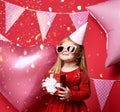 Adorable pretty girl with pink balloons and red present gift and birthday cap Royalty Free Stock Photo