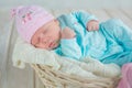 Adorable qute baby girl sleeping in white basket on wooden floor Royalty Free Stock Photo