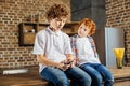 Adorable redhead kid looking at older brother listening to music Royalty Free Stock Photo