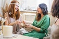 Adorable redhead woman taking wrapped gift box celebrating birthday in modern hippie bohemian style