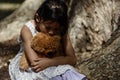 Adorable sad girl with teddy bear in park, Royalty Free Stock Photo