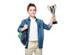 adorable schoolboy with backpack holding winner cup