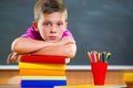 Adorable schoolboy with stack of books