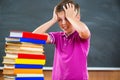 Adorable schoolboy with stack of books