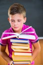 Adorable schoolboy with stack of books