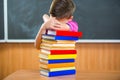 Adorable schoolboy with stack of books