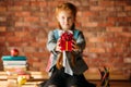 Adorable schoolgirl holds out a gift, front view