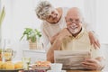 Couple at home reading newspaper together at breakfast table Royalty Free Stock Photo