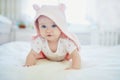 Baby girl relaxing in bedroom in pink clothes or towel with ears Royalty Free Stock Photo