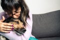 Adorable shot of Hispanic young woman kissing ang hugging her dog at home Royalty Free Stock Photo