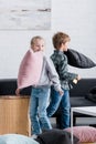adorable siblings fighting with pillows and having fun