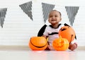 Adorable smiling African baby kid dressing up in vampire fancy Halloween costume with black bat wings, cheerful little cute child Royalty Free Stock Photo