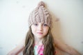 Adorable smiling child girl in beige knitted hat