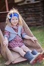 Adorable smiling child girl sitting in wheelbarrow in spring garden Royalty Free Stock Photo