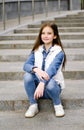 Adorable smiling little girl child preteen sitting on the steps