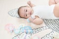 Adorable smiling happy asian baby boy having fun with toys on play mat. Happy healthy kid playing on floor with mobile educational Royalty Free Stock Photo