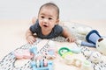 Adorable smiling happy asian baby boy having fun with toys on play mat. Happy healthy kid playing on floor with mobile educational Royalty Free Stock Photo