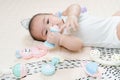 Adorable smiling happy asian baby boy having fun with toys on play mat. Happy healthy kid playing on floor with mobile educational Royalty Free Stock Photo