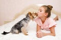 Adorable smiling happy little girl child playing with puppy yorkshire terrier