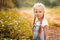 Adorable smiling little blonde girl with braided hair. Cute child having fun on a sunny summer day outdoor.