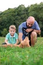 Adorable smiling little boy with his hipster father, playing with pet dog Royalty Free Stock Photo