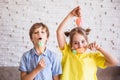 Adorable girl and boy holding colorful sweet meringues on a stick on Easter day