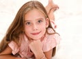 Adorable smiling little girl child is resting on a bed Royalty Free Stock Photo