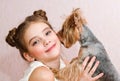 Adorable smiling little girl child schoolgirl holding and playing with pet dog Royalty Free Stock Photo