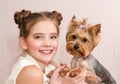 Adorable smiling little girl child schoolgirl holding and playing with pet dog Royalty Free Stock Photo